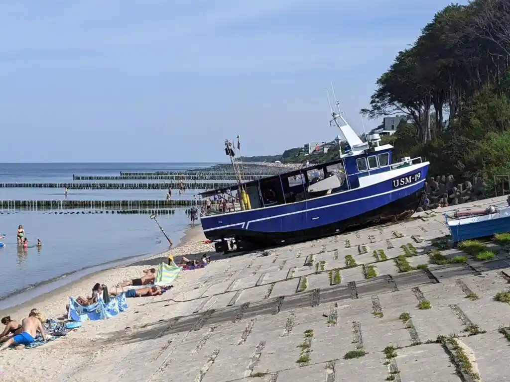 Przystań rybacka z kutrem w tle.